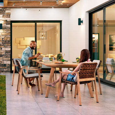 Couple enjoying patio outside with sliding glass doors showing